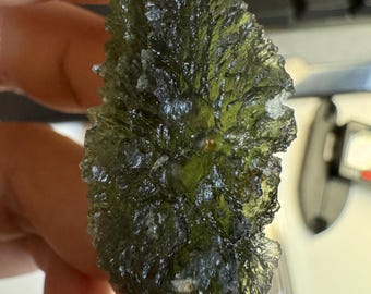 May include: A dark green, rough-textured, naturally formed rock with a unique, leafy appearance.