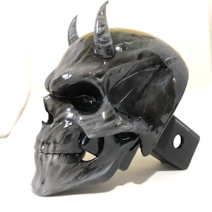 May include: Black and white skull hitch cover with horns. The skull has a detailed design and a glossy finish.