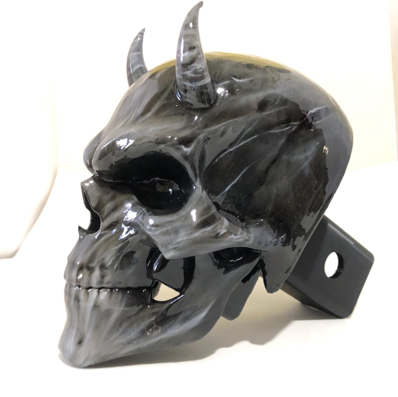 May include: Black and white skull hitch cover with horns. The skull has a detailed design and a glossy finish.