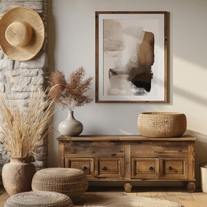 May include: A room decorated in a rustic style, featuring a wooden cabinet, framed abstract art, and decorative items. A woven hat hangs on a stone wall. The room includes dried plants in vases and a woven basket.