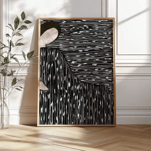 May include: Abstract art print in a wooden frame. The artwork features a figure with a black and white striped dress and a black and white background. The art print is displayed on a light wood floor.