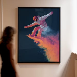 Peut inclure: Impression artistique encadrée d'un snowboarder en plein saut sur fond bleu foncé. Le snowboarder porte une tenue blanche et un casque orange, avec un effet de nuage orange et violet vif. L'œuvre est présentée dans un cadre noir, idéale pour la décoration.