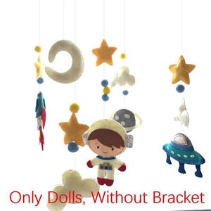 May include: A baby mobile with felt space-themed decorations. It features an astronaut, stars, a moon, clouds, a planet, and a UFO. The text at the bottom reads "Only Dolls, Without Bracket."