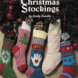 May include: Knit Christmas Stockings by Sandy Scoville, a book featuring patterns for five different Christmas stockings. The stockings are knitted in various colors and patterns, including red, white, green, blue, and yellow. The book cover features a close-up of the stockings.