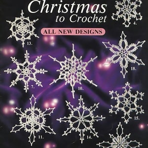 以下が含まれることがあります： 「ホワイトクリスマス・クロシェ」というタイトルの冊子で、紫色の背景に22個のクロシェ編みの雪の結晶が描かれています。この冊子は、レジャーアーツから出版されており、1321番のリーフレットです。