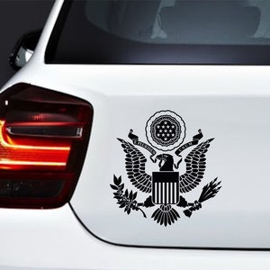 Pode incluir: Adesivo de vinil preto e branco do Grande Selo dos Estados Unidos, apresentando uma &aacute;guia com as asas abertas, um escudo com listras verticais e as palavras "E Pluribus Unum".