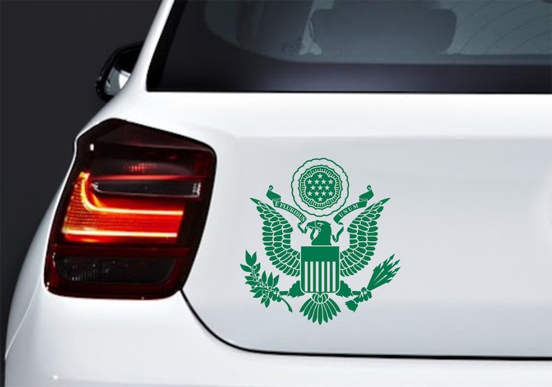 Pode incluir: Adesivo de vinil verde do Grande Selo dos Estados Unidos, apresentando uma &aacute;guia com as asas abertas, um escudo com listras verticais, um ramo de oliveira e flechas. O texto "E PLURIBUS UNUM" &eacute; exibido acima da &aacute;guia.