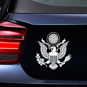 Pode incluir: Adesivo de vinil branco do Grande Selo dos Estados Unidos, com uma &aacute;guia de asas abertas, um escudo com listras verticais e uma faixa com as palavras "E Pluribus Unum".
