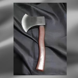 May include: A single-bit axe featuring a polished silver-coloured metal head with a curved cutting edge and a smooth, dark brown handle with a slight ergonomic curve. The axe head is securely attached to the top of the wooden-toned handle.