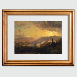 Puede incluir: Una pintura de paisaje enmarcada que representa una cordillera con un cielo de puesta de sol dorado. Las montañas están cubiertas de árboles y el cielo está lleno de nubes. La pintura está enmarcada en un marco dorado.