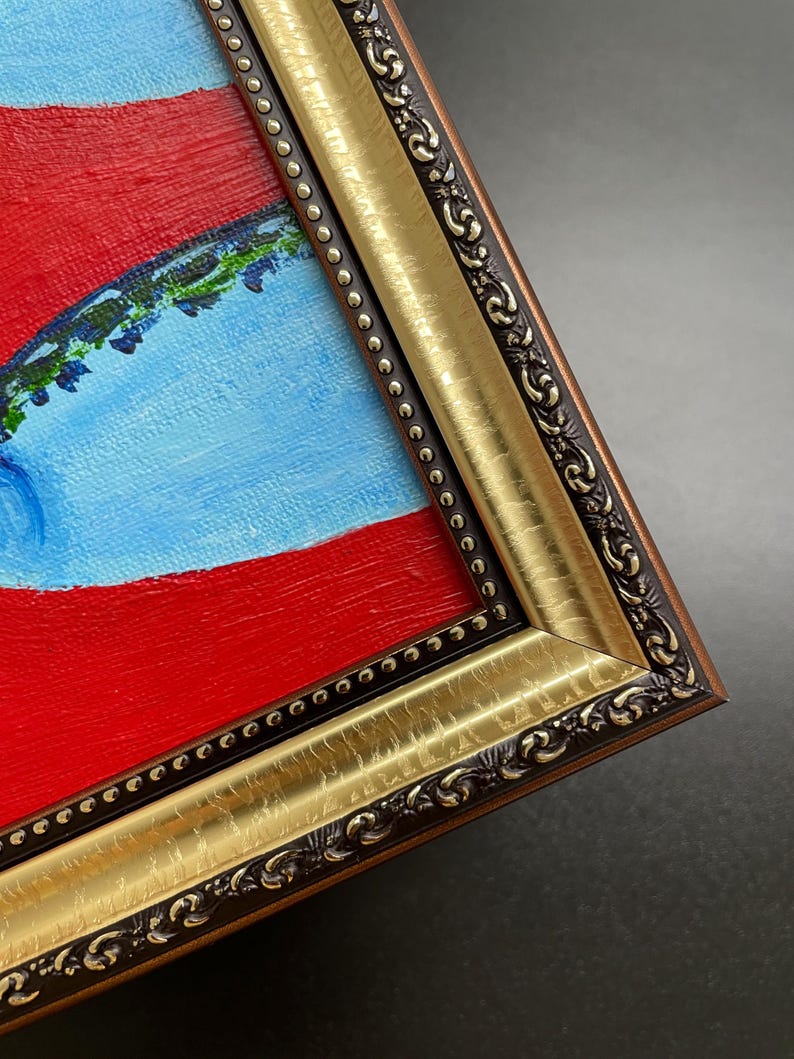 May include: Close-up of a framed painting with a vibrant color palette. The artwork features a bold red background, a light blue shape, and green accents. The frame is ornate, with gold and dark brown detailing.