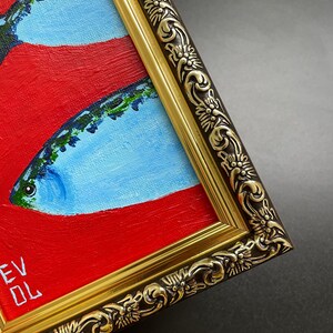 May include: An original oil painting of fish with red and blue hues, framed in a gold ornate frame. The artwork features a close-up view of the fish, with the artist's initials visible in the lower left corner.