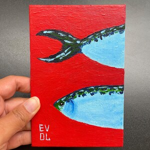 May include: Small rectangular painting featuring two stylized fish against a vibrant red background. The fish are painted in shades of blue and green, with a textured appearance. The artist's initials, "EV DL", are visible in the lower left corner.