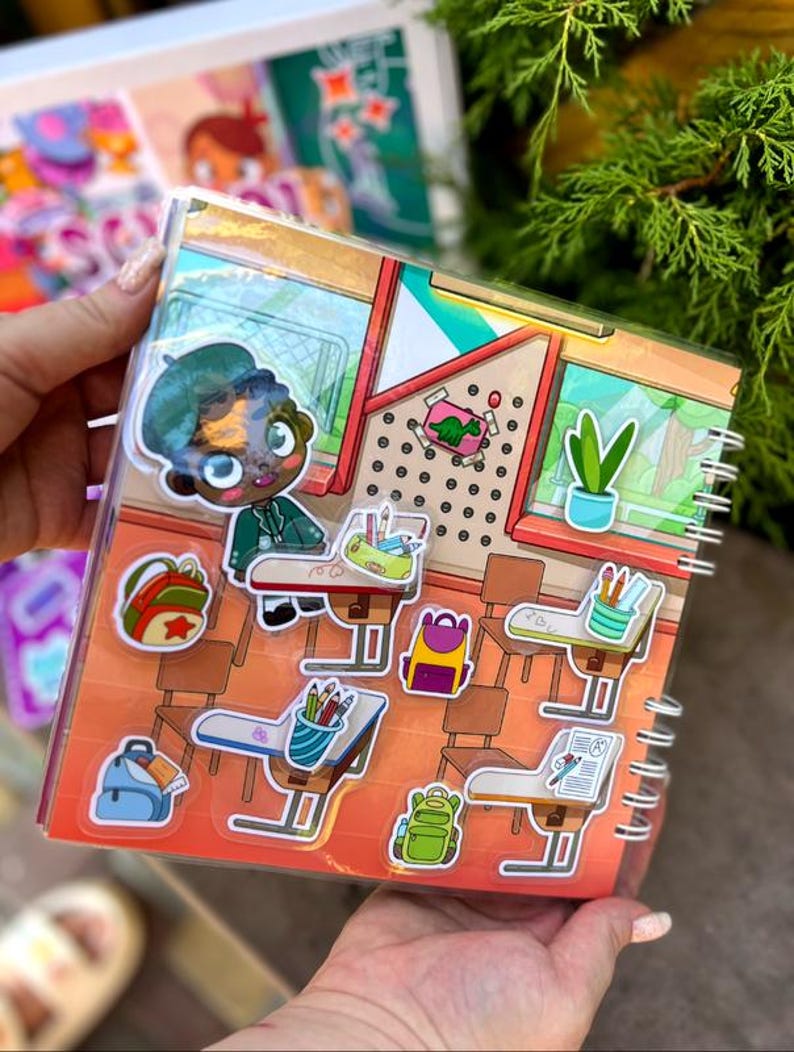 May include: A spiral-bound sticker book featuring a school-themed design. The cover shows a cartoon student and classroom scene. Stickers include backpacks, desks, pencils, and a dinosaur. The color palette includes orange, green, blue, and brown.