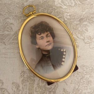Antique hand colored photograph in oval frame