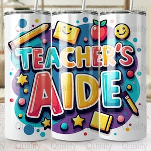 Op de afbeelding: Een witte beker met de tekst "TEACHER'S AIDE" in kleurrijke letters. Het ontwerp bevat een potlood, een appel, sterren en een smiley. De beker heeft een rietje.