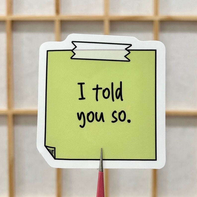 May include: A green sticky note with a black border and a white tape design at the top. The note says "I told you so."