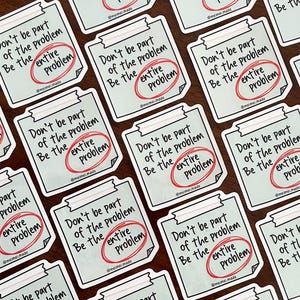May include: A collection of stickers with a light blue background and white text that reads "Don't be part of the problem. Be the entire problem." The text is circled in red.