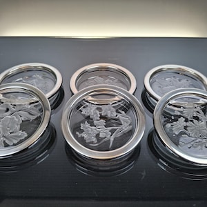 6 crystal coasters with silver-plated edge.