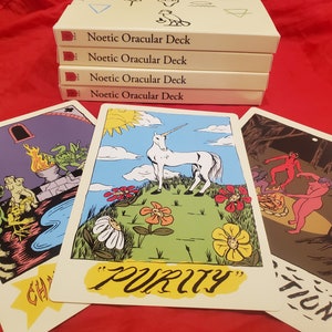May include: Three tarot cards with colorful illustrations. The card on the left shows a green creature with a fire behind it. The middle card shows a white unicorn in a field of flowers with the word "PURITY" written below. The card on the right shows a group of people dancing around a fire in a dark forest.