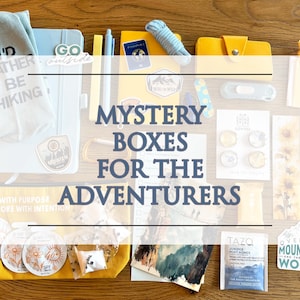 May include: A collection of outdoor-themed items including a light blue notebook, a yellow pencil case, a passport, a yellow wallet, stickers, a keychain, sunscreen packets, a tea bag, and a cloth with the text I'D RATHER BE HIKING.