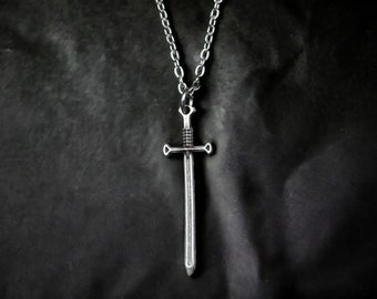 May include: A silver sword pendant necklace with a chain. The sword has a pointed tip and a cross guard.