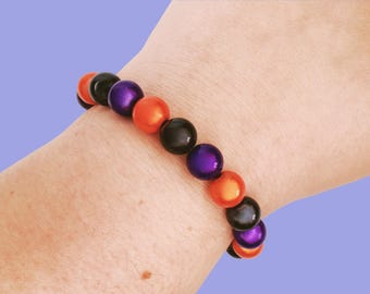 Pulseira refletora de Halloween com miçangas Miracle Glow de 10 mm, nas cores roxa, preta e laranja.