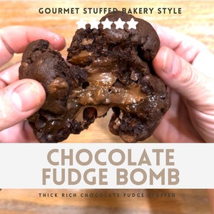 Peut inclure: Un cookie bombe au chocolat et au fudge, cassé en deux pour révéler une épaisse garniture de fudge au chocolat. Le cookie est brun foncé et a une texture légèrement croustillante. La garniture au fudge est d'une couleur brun foncé riche et a une texture lisse et crémeuse. Le cookie est tenu dans deux mains, et le texte "Gourmet Stuffed Bakery Style" et "Chocolate Fudge Bomb" est visible sur l'image.