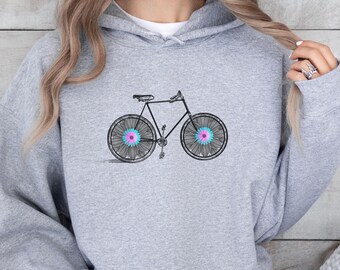 Op de afbeelding: Een grijs hoodie met een zwarte fiets afbeelding. De fiets heeft roze en blauwe bloemen op de wielen.