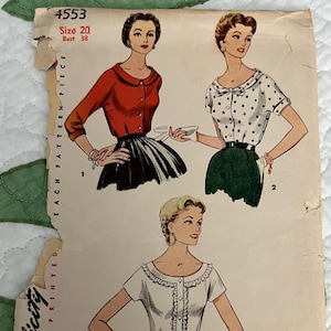 May include: Vintage Simplicity sewing pattern featuring illustrations of three different blouse designs. The pattern includes a red cardigan, a polka dot blouse, and a white blouse with a ruffled neckline. The pattern is size 20, bust 38.