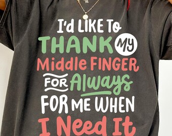 May include: Dark gray t-shirt with the text "I'd LIKE TO THANK MY Middle Finger FOR Always FOR ME WHEN I Need It" in green, red, and white. The shirt has a relaxed fit and short sleeves.