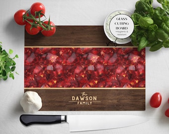 May include: A rectangular wooden cutting board with a red and gold patterned center and a dark brown border. The text "The DAWSON FAMILY" is printed on the bottom. A white bowl, tomatoes, and a knife are also present.