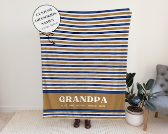 May include: A personalized blanket with horizontal stripes in navy blue, gold, and white. The bottom features a gold band with the word "GRANDPA" and the names of the grandkids. The blanket is a custom gift option.
