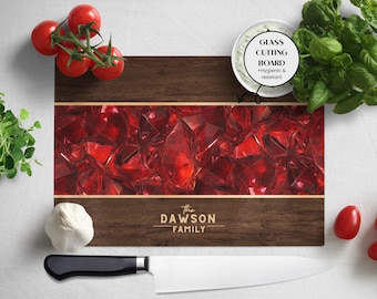 May include: A rectangular glass cutting board with a dark wood grain border and a central design of red gemstones. The text "The Dawson Family" is printed on the bottom. The board is labeled "Glass Cutting Board + Hygienic & resistant".