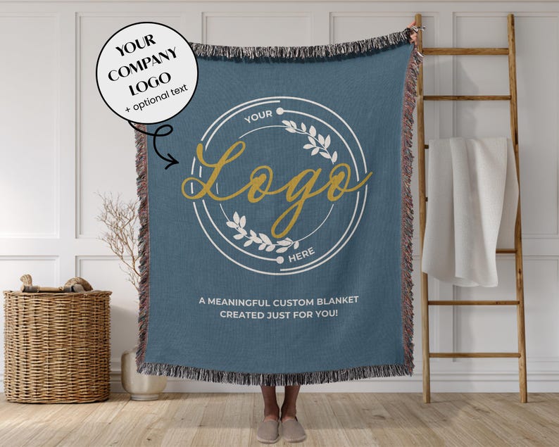 May include: A blue woven blanket with a custom logo design. The blanket features a circular logo with text and a floral design. The text on the blanket reads "YOUR LOGO HERE" and "A MEANINGFUL CUSTOM BLANKET CREATED JUST FOR YOU!"