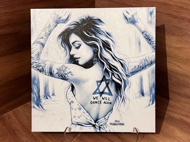 May include: A blue and white illustration of a woman with long hair and tattoos. She is wearing a white dress and has a Star of David tattoo on her back. The text "We will dance again" is written below the tattoo. The artist's name, "Ron Yishai-evich", is written in the bottom right corner.
