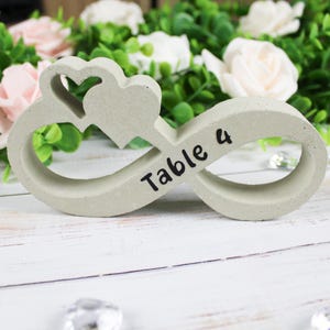 May include: A gray concrete infinity symbol with a heart cutout and the text "Table 4" on it.