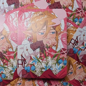 May include: A stack of pink and red art prints featuring an anime-style character with blonde hair and blue eyes. The prints have the text "Please Be Mine" and a floral bouquet design.