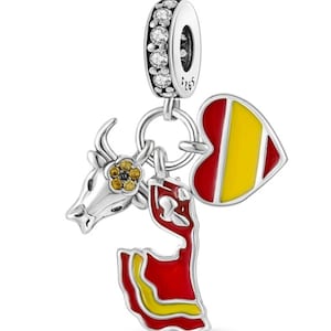 May include: Silver charm with a red and yellow heart, a red and yellow Spanish dancer, and a silver bull with a yellow flower. The charm has a silver ring with clear crystals.