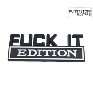 Könnte beinhalten: Ein schwarz-weißes "FUCK IT EDITION" Emblem. Der Text ist fett und ohne Serifen. Die Worte "FUCK IT" sind über einem rechteckigen Banner angeordnet, auf dem "EDITION" in weißen Buchstaben steht. In der oberen rechten Ecke befindet sich ein kleines weißes Rechteck mit deutschem Text.