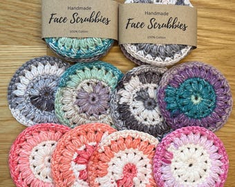 Peut inclure: Collection de débarbouillettes faites à la main, 100% coton, de différentes couleurs, dont le turquoise, le gris, le violet et le rose. Chaque débarbouillette circulaire présente un motif crocheté. Deux débarbouillettes ont des étiquettes en papier brun avec "Handmade Face Scrubbies".