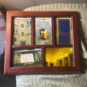 May include: A wooden picture frame containing five photographs. The images depict a building with green accents, a coffee press, a door, a towel, and a porch with fairy lights.