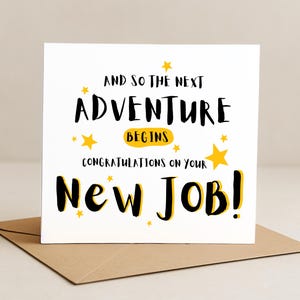 May include: A white card with the message "And so the next adventure begins. Congratulations on your new job!" in black and yellow text. The card features star illustrations and sits on a brown envelope.