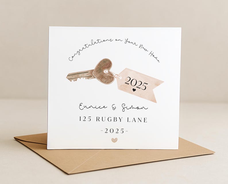 Puede incluir: Tarjeta cuadrada con una ilustraci&oacute;n de una llave con cabeza en forma de coraz&oacute;n y una etiqueta que dice "2025". La tarjeta dice "Felicitaciones por tu nuevo hogar" e incluye los nombres "Eunice & Simon" y la direcci&oacute;n "125 Rugby Lane."