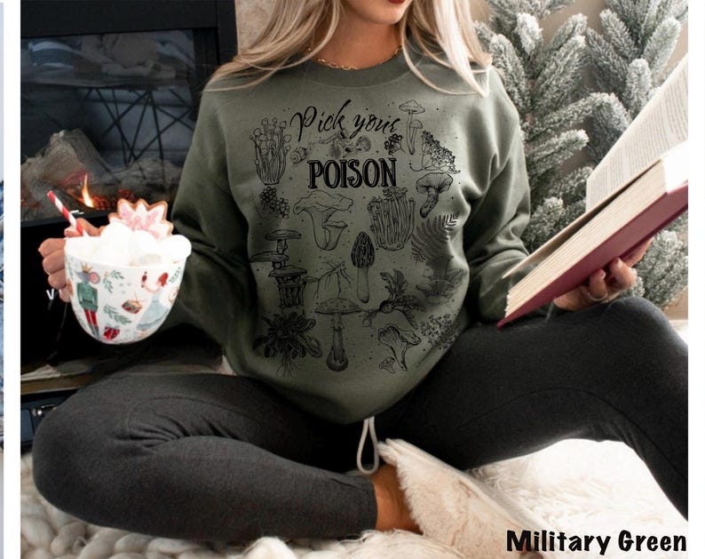 May include: Military green sweatshirt with a black graphic of various mushrooms and the text "Pick your POISON". The sweatshirt is made of a soft material.