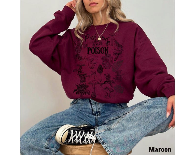 May include: Maroon sweatshirt with a black graphic design featuring mushrooms and the text "Pick Your Poison". The sweatshirt is a long-sleeved crew neck style.