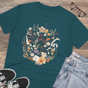 May include: Teal blue t-shirt with a floral print of dried flowers in shades of white, yellow, orange, purple, and brown.