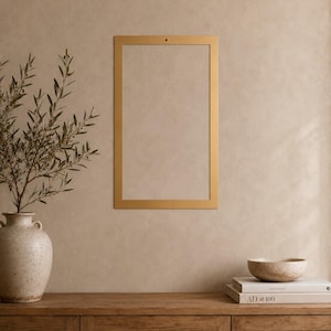 May include: A rectangular gold-colored metal frame with a single small hole at the top center for mounting. The frame is empty, featuring a clean, flat surface and a uniform metallic finish, designed for wall display of prints or photographs.