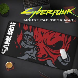 Może przedstawiać: Czarno-czerwona podkładka pod mysz w stylu Cyberpunk z wzorem samuraja. Podkładka pod mysz przedstawia czerwoną i czarną maskę samuraja z cybernetycznym okiem i napisem "SAMURAI" w kolorze białym po lewej stronie. Napis "CYBERPUNK MOUSE PAD/DESK MAT" jest w kolorze żółtym i zielonym na czarnym tle.
