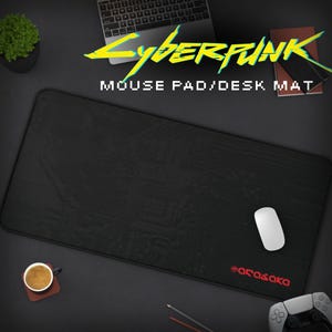 Może przedstawiać: Czarna podkładka pod mysz z cyberpunkowym wzorem i tekstem "Cyberpunk Mouse Pad/Desk Mat" w kolorze żółtym. Podkładka pod mysz ma subtelny wzór płytki drukowanej i tekst "#arasaka" w kolorze czerwonym w prawym dolnym rogu.